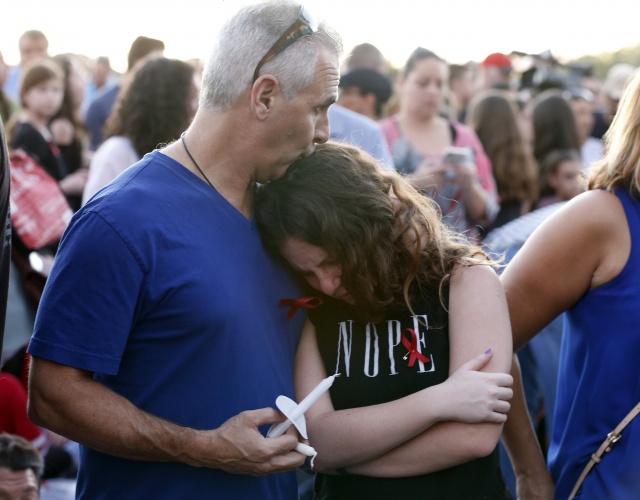Tears and guilt grip survivors at US school shooting vigils
