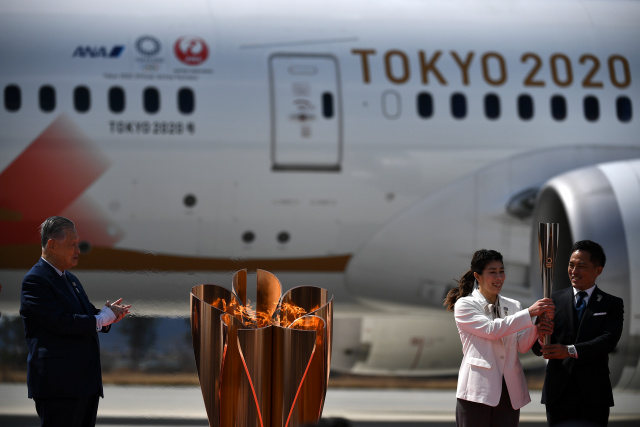 Japan welcomes Olympic flame as doubts swirl over Games