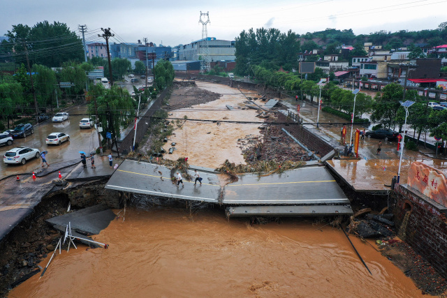 Chinese city picks through the debris after record rains kill 33